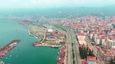 Merkez, Rize, Türkiye - 4 Mart 2024 'te Şenlikli Şehir Ana Yolu ve Sakin Sahil Tarafı' na Kuş Gözü Bakışı Nehir ve karayolu olan bir şehrin havadan görünüşü