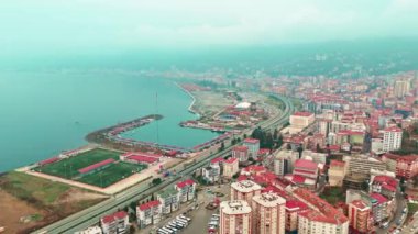 Merkez, Rize, Türkiye - 4 Mart 2024 'te Kentin Hareketli Ana Yolu ve Sakin Sahil Yakası' na Kuş Gözü Bakışı Deniz ve futbol sahası olan bir şehrin havadan görünüşü