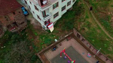 Merkez, Rize, Türkiye - 4 Mart 2024 'te Parlak Şehir Ana Yolu ve Sakin Sahil Tarafının Sarı şemsiyeli ve oyun alanı yapısına sahip bir oyun parkının havadan görünüşü