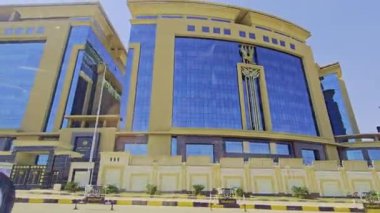 Gökyüzü arkaplanı olan bir binada saati olan bir cami.