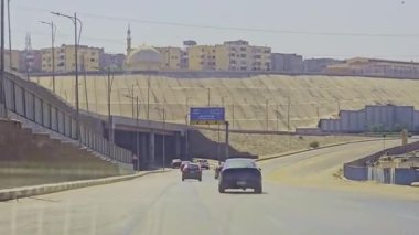 Gökyüzü arkaplanı olan bir binada saati olan bir cami.