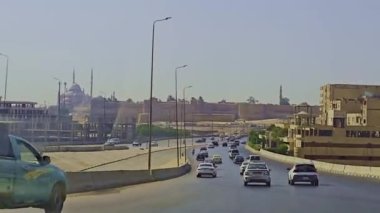 Gökyüzü arkaplanı olan bir binada saati olan bir cami.