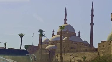 Gökyüzü arkaplanı olan bir binada saati olan bir cami.
