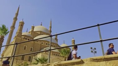 Gökyüzü arkaplanı olan bir binada saati olan bir cami.