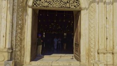 Gökyüzü arkaplanı olan bir binada saati olan bir cami.