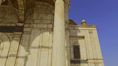 Gökyüzü arkaplanı olan bir binada saati olan bir cami.
