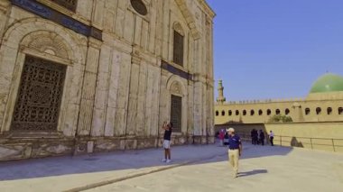 Gökyüzü arkaplanı olan bir binada saati olan bir cami.