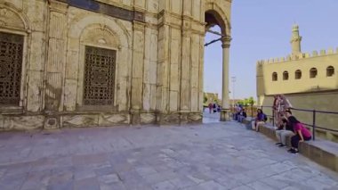 Gökyüzü arkaplanı olan bir binada saati olan bir cami.