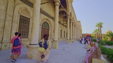 Gökyüzü arkaplanı olan bir binada saati olan bir cami.