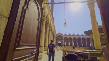 Gökyüzü arkaplanı olan bir binada saati olan bir cami.