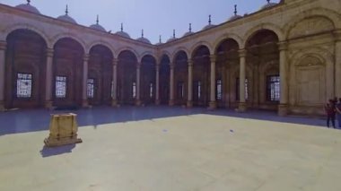 Gökyüzü arkaplanı olan bir binada saati olan bir cami.