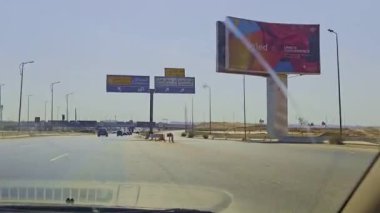 Yolun kenarında büyük bir ilan panosu.