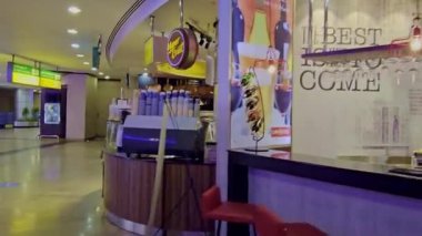 Bar taburesi ve ışıklı tabelası olan bir bar.