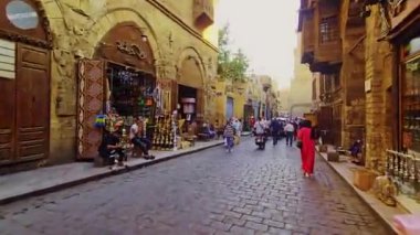 Bir adam dar bir sokakta yürüyor.