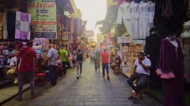Kalabalık bir markette sokakta yürüyen bir adam.