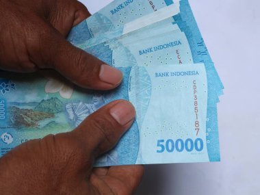 : Birisi Endonezya 'dan gelen 50 bin banknotları tutuyordu.