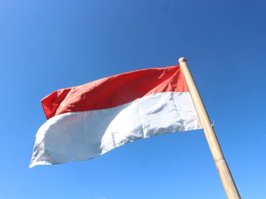 Endonezya Cumhuriyeti 'nin kırmızı ve beyaz bayrağı bir bambu çubuğuna bağlıdır.