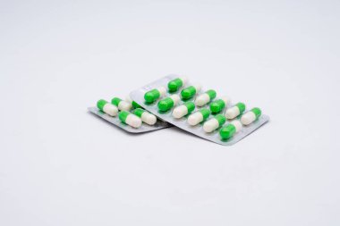 Beyaz arka planda iki plaka amoxilin antibiyotik kapsülü.