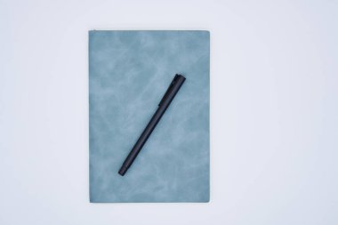 beyaz arkaplanda kalem ve defter