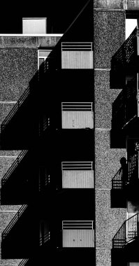 Beton panelli Avrupa gökdelenli siyah beyaz zıt güneş ışığı ve sert gölgelerle apartman dairesi.