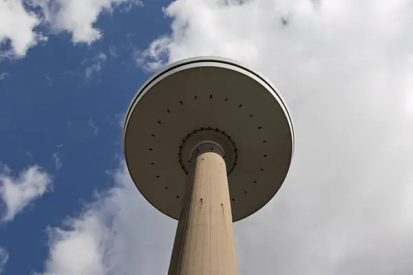 Mavi gökyüzüne karşı Kiel şehrindeki uzun televizyon kulesi. Aşağıdan bak. Beton ayaklı kocaman bir tabak..