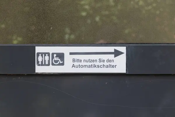 Siyah kapıdaki camda otomatik kapı açma düğmesinin Almanca kullanıldığı yazıyor.
