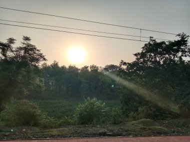 Güneşin doğduğu güzel bir dağ. Tepelerin arkasından doğan güneşin altın ışığı pirinç tarlalarında parlıyor..