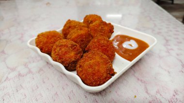 Beyaz Tabakta Veg Pakora, cam masanın üstünde. Lezzetli çıtır sebzeli kukure Momos. Kukure Momo Görüntülenecek.