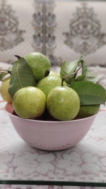 Fresh guava fruit isolated on Glass Table. Fresh guava fruits in basket, isolated on pink background. clipart