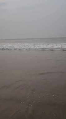 Gün batımında kumlu sahilde dalgaların gökyüzüne doğru aktığı manzara. Yüksek kalite Tam HD görüntü.