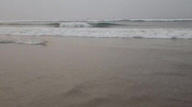 Köpüklü deniz dalgaları kumsala gelir güneşli yaz mevsiminde güzel.