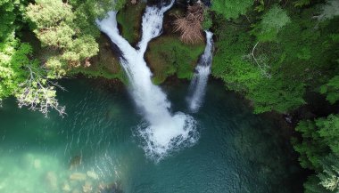 Bir şelale göle akıyor. Su berrak ve sakin. Huzurlu ve huzurlu bir sahne.