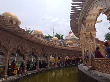 Gökyüzü arkaplanlı güzel balık havuzu fotoğrafçılığı olan büyük cami binası. Altın kubbeler dizildi