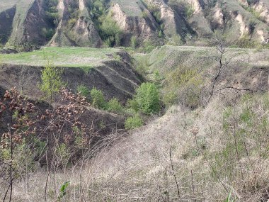 Bulutlu bir bahar gününde tepeler ve vadilerle manzara.