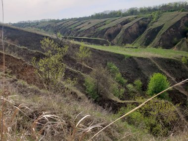 Bulutlu bir bahar gününde tepeler ve vadilerle manzara.