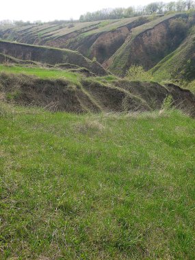 Bulutlu bir bahar gününde tepeler ve vadilerle manzara.