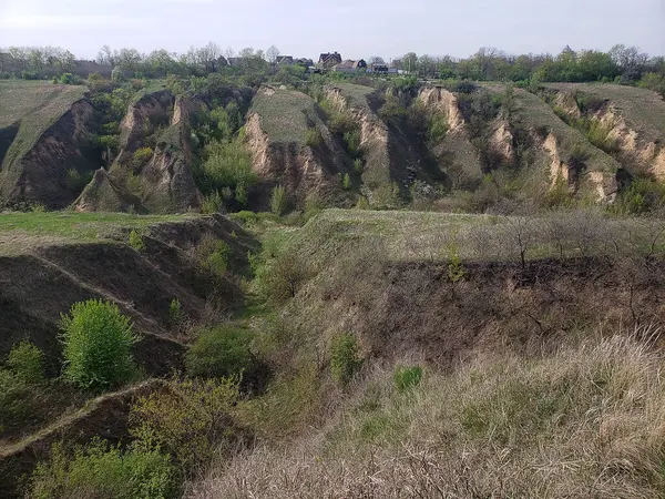 Bulutlu bir bahar gününde tepeler ve vadilerle manzara.