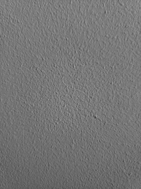 Arkaplanı alçı desenli gri duvar.