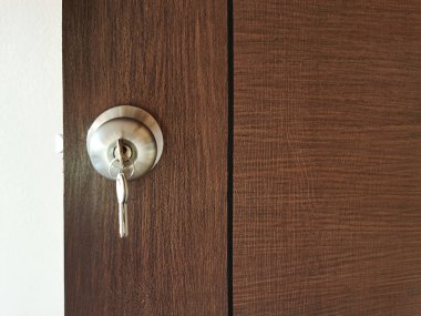 Ev anahtarı ahşap kapıdaki anahtar deliğinde.