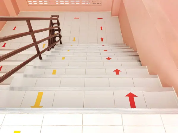 The stairs go up and down the building with red yellow arrows fo