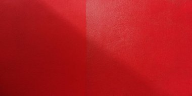 Kırmızı beton duvarın arkasında gölgeler var..