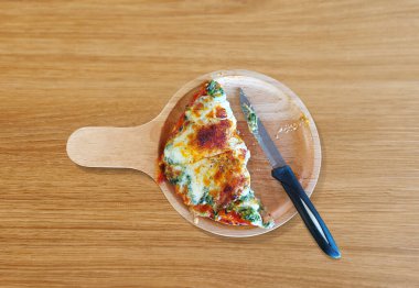 Ispanaklı ve peynirli pizza, ikiye bölünmüş, İtalyan yemeği, ahşap bir masada..