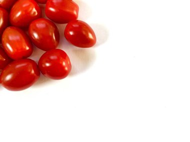 Kırmızı kiraz domatesleri beyaz bir arkaplanda izole edilmiş ve kopyalama alanı var