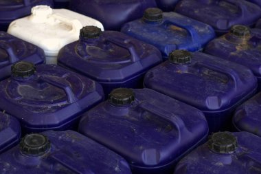 Bir depodaki tozlu mavi bidon.