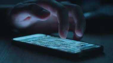 Genç Adam Cep Telefonu ve Sosyal Ağ 'a bak. Yakından bak. Rahat Yetişkin Erkek Okuma Uygulaması Cep Telefonu Geceleri. Genç adam akıllı telefon kullanıyor.