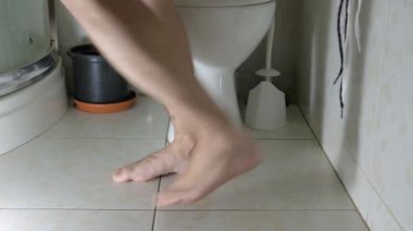 Mide sorunları ve ishali olan bir adam tuvalete koşar. Adam tuvalette oturuyor.
