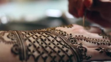 Genç bir gelinin elinde kına yapan kadın.