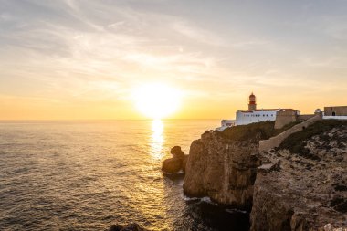 Farol do Cabo de Sao Vincente in Sagres, Algarve Portugal 'da. Güzel altın bir günbatımında mavi denize bakan