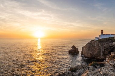 Farol do Cabo de Sao Vincente in Sagres, Algarve Portugal 'da. Güzel altın bir günbatımında mavi denize bakan