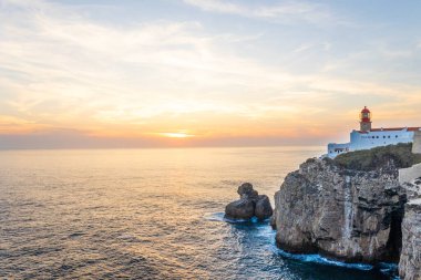 Farol do Cabo de Sao Vincente in Sagres, Algarve Portugal 'da. Güzel altın bir günbatımında mavi denize bakan